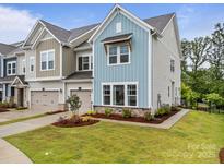 Charming townhome showcasing craftsman-style architecture, a 2-car garage, and a landscaped yard at 8215 Houser St, Cornelius, NC 28031