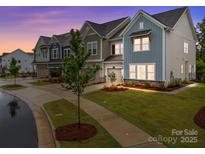 Charming townhome exterior featuring colorful siding, well-manicured landscaping, and attached garage at 8215 Houser St, Cornelius, NC 28031