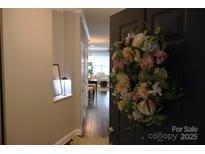 Inviting entryway with wood floors and a charming floral wreath adorning the front door at 1000 E Woodlawn Rd # 107, Charlotte, NC 28209