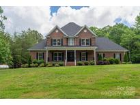 Charming two-story brick home featuring a covered porch and well-manicured lawn at 106 Hannaford Pl # 15, Gastonia, NC 28052