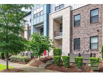Modern townhome with brick and stone facade, red door, and landscaped front yard at 1162 E 36Th St, Charlotte, NC 28205