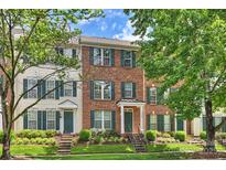 Charming brick townhome featuring well-manicured landscaping and a welcoming front entrance with green shutters at 15639 Sir Charles Pl, Charlotte, NC 28277