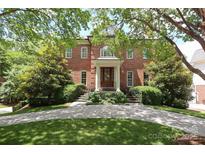 Stately brick home with mature trees and a well-manicured lawn offers timeless curb appeal at 1638 Myers Park Dr, Charlotte, NC 28207