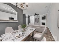 Bright and airy living room featuring a marble dining table, white sofa, fireplace, and a seamless flow to the kitchen at 1915 Travertine Ln, Fort Mill, SC 29708