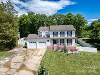 Charming two-story home featuring a three-car garage, front porch, and lush landscaping at 2008 Bantry Ln, Charlotte, NC 28262