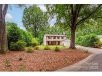 Charming two-story home with a well-manicured front yard, mature trees, and a double garage at 5604 Bethesda Ct, Charlotte, NC 28226