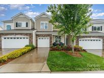 Charming townhome exterior with stone accents, a well-manicured lawn, and an attached one-car garage at 829 River Park Rd, Belmont, NC 28012
