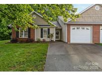 Inviting single-story home with attached two-car garage, black shutters, and a manicured lawn at 112 Dujon Ct, Mount Holly, NC 28120