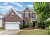 Beautiful two-story brick home featuring an attached two-car garage and a well-manicured lawn at 11526 Mcginns Trace Ct, Charlotte, NC 28277