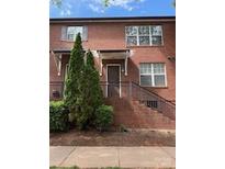 Charming brick townhouse featuring a cozy front porch and well-maintained landscaping at 120F Steinbeck Way, Mooresville, NC 28117