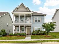 Charming two-story home featuring a double porch, stone accents, and manicured landscaping at 134 Kerri Dawn Ln # 117, Locust, NC 28097