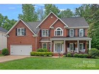 Beautiful two-story brick home with a manicured lawn and welcoming front porch at 1402 Coachman Dr, Waxhaw, NC 28173