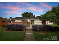 Charming single-story home featuring a brick and stone facade with a well-manicured lawn and shrubs at 4226 Randolph Rd, Charlotte, NC 28211