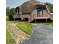 Unique dome home featuring a spacious deck, mature landscaping, and a paved driveway at 443 Troutman Farm Rd, Statesville, NC 28677