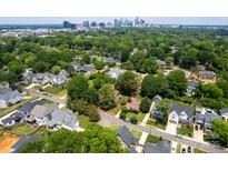 A beautiful bird's eye view of a property in a mature neighborhood with a distant view of the city's skyline at 557 Melbourne Ct, Charlotte, NC 28209