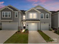 Charming townhome featuring a one-car garage, inviting facade, and well-maintained landscaping at 5625 Axil Ln, Charlotte, NC 28269
