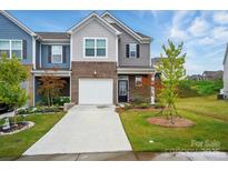 Charming townhome with well-manicured lawn, attached garage, and inviting curb appeal at 6037 Chelsea Oaks Rdg # 77, Tega Cay, SC 29708