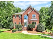Charming two-story brick home with manicured lawn and mature trees at 655 Powder Horn Ln, Indian Trail, NC 28079