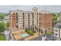 A multi-story building features brick and stucco accents, balconies, a pool, and modern outdoor art at 715 N Church St # 613, Charlotte, NC 28202