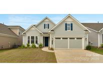 Charming home with light gray siding, blue shutters, a two-car garage, and a well-manicured lawn at 7332 Jolly Brook Dr, Charlotte, NC 28215