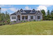 Striking stone and gray siding with a manicured lawn adds curb appeal to this home at 7517 Lancaster Hwy # 5, Waxhaw, NC 28173