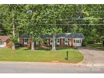 Charming brick home with mature trees, well-maintained lawn, and an inviting curb appeal at 844 Fieldstone Rd, Mooresville, NC 28115