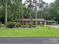 Charming brick home with a lush front yard and mature trees at 8524 Anette Ave, Mint Hill, NC 28227