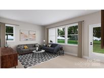 Cozy living room featuring two sofas, modern decor, neutral walls and large windows overlooking a green outdoor space at 917 Archway Ln, Charlotte, NC 28217
