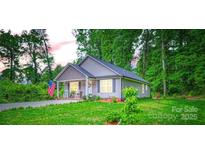 Charming single-story home with inviting front porch, well-manicured lawn, and patriotic American flag waving proudly at 105 W 17Th St, Salisbury, NC 28144