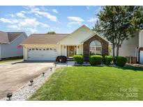 Charming single-story home with manicured lawn, brick accents, and attached two-car garage at 1076 Braxton Dr, Concord, NC 28025