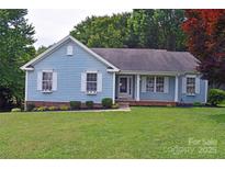 Charming blue home with white trim, lush lawn, and a welcoming front entrance with decorative window boxes at 117 Blackberry Ln # 66, Mooresville, NC 28117
