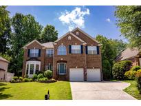Charming two-story brick home with a well-manicured lawn, two-car garage, and inviting curb appeal at 12416 Kane Alexander Dr, Huntersville, NC 28078