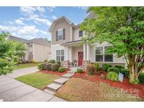 Charming home with a beautifully landscaped front yard and welcoming red door at 12832 Heath Grove Dr, Huntersville, NC 28078