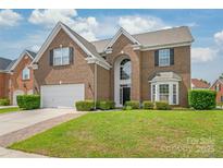 Charming brick home with well-manicured lawn, two-car garage, and inviting front entrance at 14104 Kendrick Cross Rd, Charlotte, NC 28273