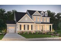 Charming two-story home with gray siding, black shutters, a well-manicured lawn, and an attached two-car garage at 14210 Kershaw Cir # 20, Huntersville, NC 28078