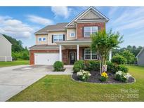 Charming two-story home with brick and beige siding, a manicured lawn, and inviting curb appeal at 14316 Baytown Ct, Charlotte, NC 28078