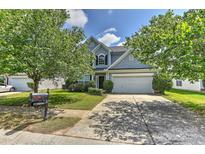 Charming two-story home with blue siding, mature trees, and a well-maintained front yard at 14501 Asheton Creek Dr, Charlotte, NC 28273