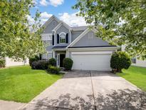 Charming two-story home with a well-manicured lawn and attached two-car garage, framed by mature trees at 14501 Asheton Creek Dr, Charlotte, NC 28273
