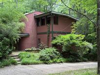 Charming two-story home features unique design, beautiful landscaping, and mature trees at 1451 Blueberry Ln, Charlotte, NC 28226