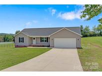 Charming single-story home with well-manicured lawn and a long driveway leading to an attached garage at 154 Stable Brook Ln, Taylorsville, NC 28681