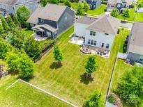Expansive backyard featuring a fire pit, patio seating, and well-maintained green space, perfect for outdoor entertaining at 16008 Weeping Valley Dr, Fort Mill, SC 29715