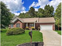 Charming brick home with a well-manicured lawn, mature trees, and an inviting front porch at 2016 Townview Dr, Kannapolis, NC 28081
