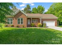 Charming brick home with a well-maintained lawn, mature landscaping, and an attached two car garage at 2016 Townview Dr, Kannapolis, NC 28081