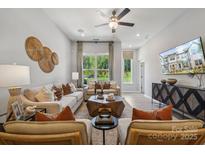 Bright living room features stylish furnishings, ceiling fan, and a large window with natural light at 3119 Beacon Heights Rd, Indian Land, SC 29707
