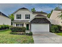 Charming home showcasing a tidy lawn, green door, and a stone-accented two-car garage at 3711 Green Pasture Rd, Charlotte, NC 28269