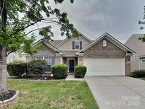 Charming brick home with a two-car garage, manicured lawn, and lush landscaping at 4006 Lawrence Daniel Dr, Matthews, NC 28104