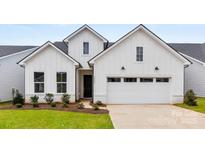 Charming new construction home with a two-car garage, black windows and door, and low maintenance landscaping at 4134 Eastover Glen Rd # 0319, Charlotte, NC 28269