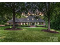 Charming brick home featuring a manicured lawn and mature trees, creating a serene and inviting atmosphere at 4920 Parview S Dr, Charlotte, NC 28226