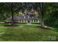 Stately brick home featuring a manicured lawn and mature trees, creating a welcoming curb appeal at 4920 Parview S Dr, Charlotte, NC 28226