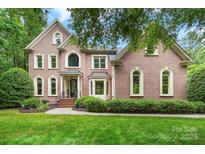 Charming two-story brick home featuring an arched entryway, bay window, and manicured landscaping at 552 Wyndham Ln, Marvin, NC 28173